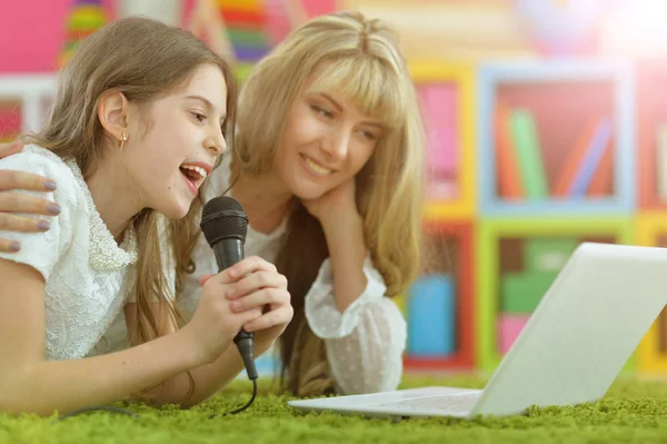 Vrouw en een meisje zingen karaoke — Stockfoto