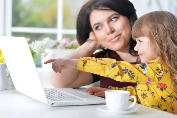 Kvinne og liten jente som bruker bærbar datamaskin – stockfoto