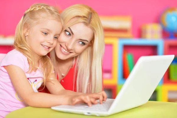 Mujer y niña utilizando el ordenador portátil —  Fotos de Stock