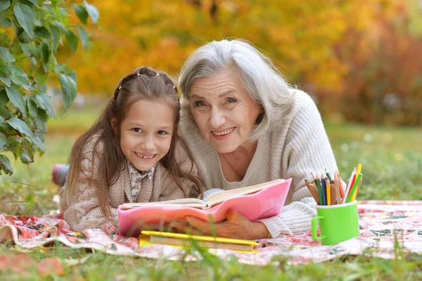 Chica con su abuela leyendo —  Fotos de Stock