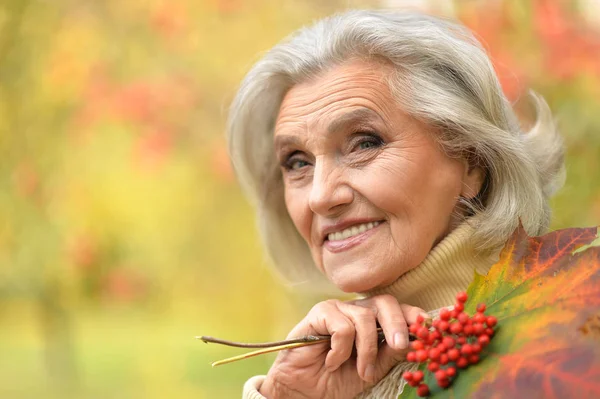 Женщина держит листья и ягоды — стоковое фото