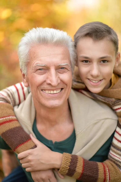 Дедушка и внук обнимаются в парке — стоковое фото