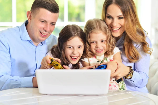 Família jogando no laptop à mesa — Fotografia de Stock