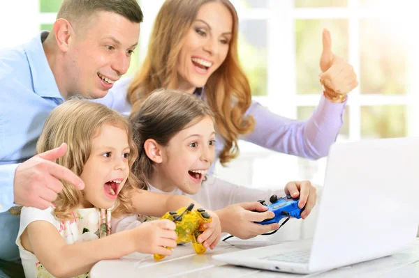 Familj spelar på laptop vid bord — Stockfoto