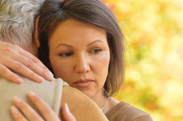 Treurige vrouw en senior man knuffelen — Stockfoto