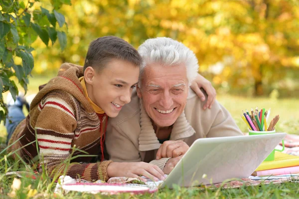 Chlapec a dědeček s notebookem — Stock fotografie