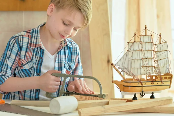 Junge mit Schiffsmodell und Handsäge — Stockfoto