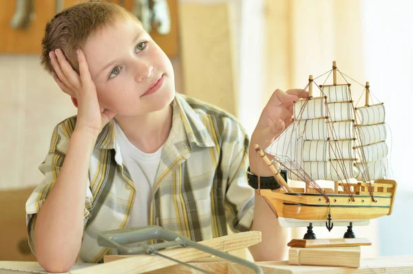 Niño con modelo de nave y sierra de mano —  Fotos de Stock