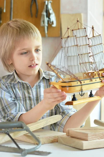 Niño con modelo de nave y sierra de mano — Foto de Stock