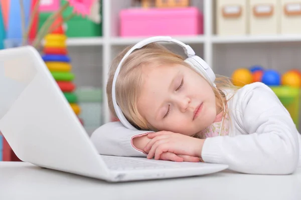 Carino bambina dormire vicino computer portatile — Foto Stock