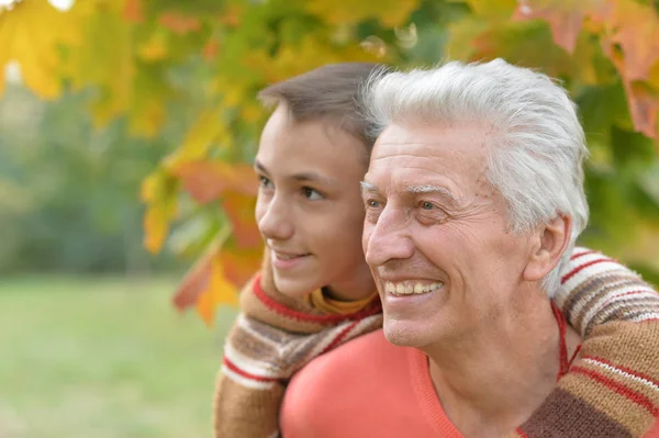 Abuelo y nieto en el parque otoñal — Foto de Stock