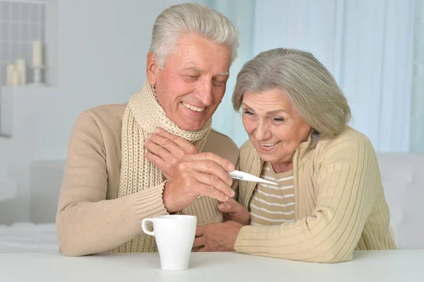 Couple with thermometer at home — Stock Photo, Image