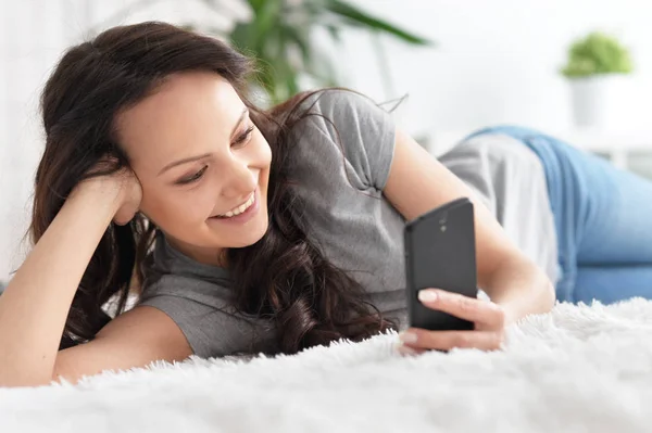 Junge Frau nutzt Smartphone — Stockfoto