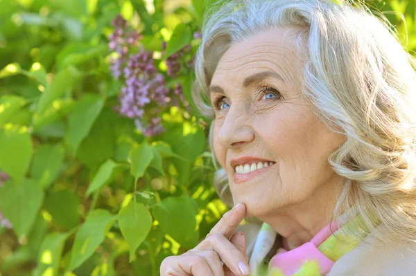 Senior Kvinna nära blommande träd — Stockfoto