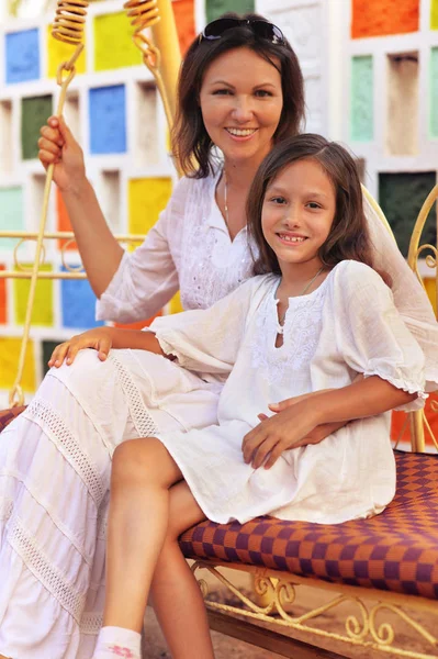 Mother and daughter sitting on soft swing — Stock Photo, Image