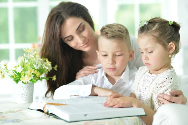 Мати і діти читають книгу — стокове фото