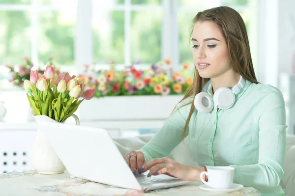 Hermosa mujer joven usando el ordenador portátil — Foto de Stock