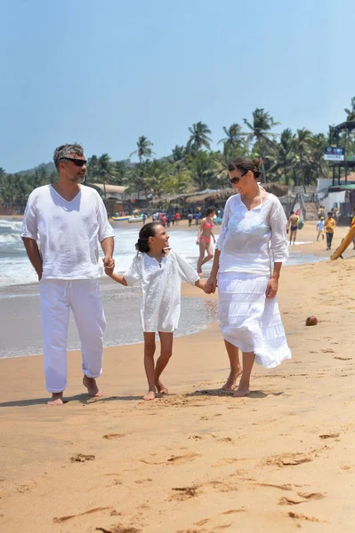 Parents avec fille marchant sur la plage — Photo