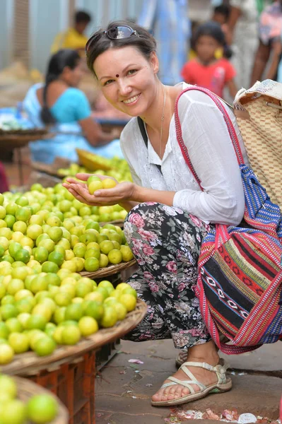 Ung kvinna anläggning citroner — Stockfoto