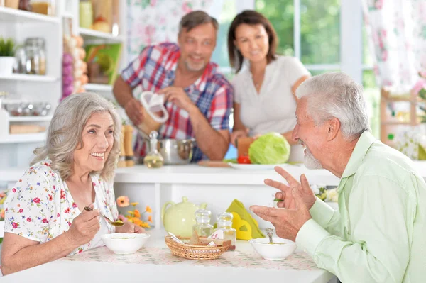 Pareja mayor comiendo en la cocina — Foto de Stock