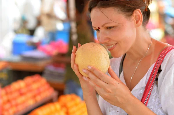 Mujer joven olfateando fruta — Foto de Stock