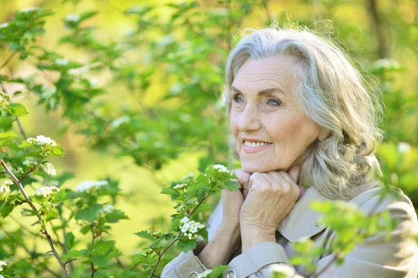 Старша жінка біля квітучого дерева — стокове фото