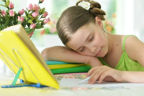 Colegiala durmiendo en el libro de ejercicios — Foto de Stock