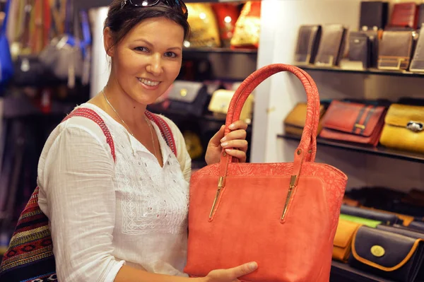 Junge Frau wählt Handtasche — Stockfoto