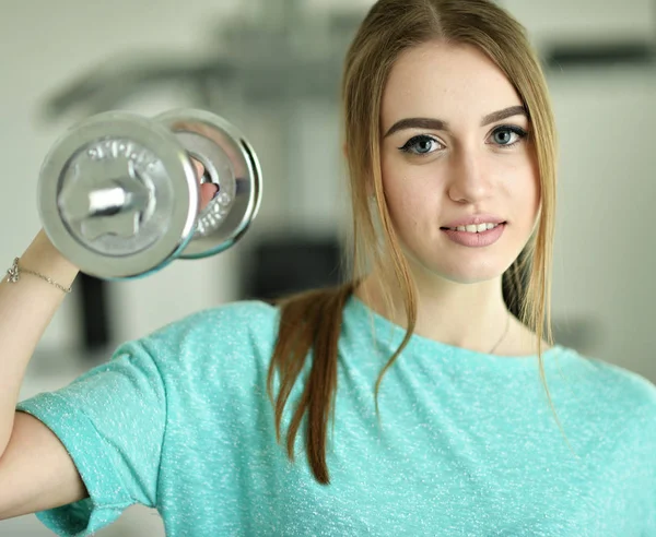 Young woman with dumbbell in gym — Stock Photo, Image