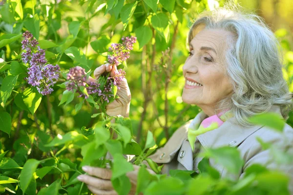 Seniorin nahe blühendem Baum — Stockfoto