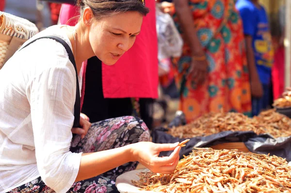 Kvinnan att välja grönsaker på marknaden — Stockfoto