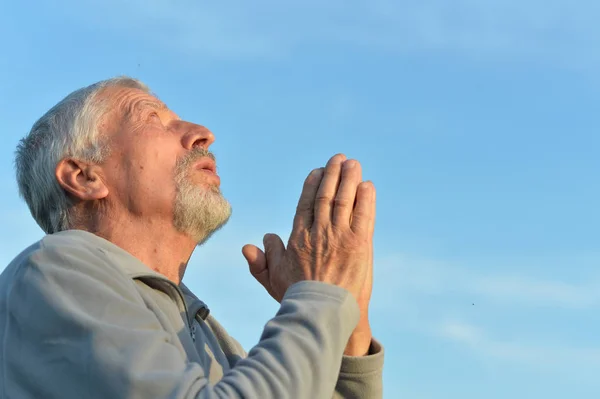 Pensando homem sênior orando — Fotografia de Stock