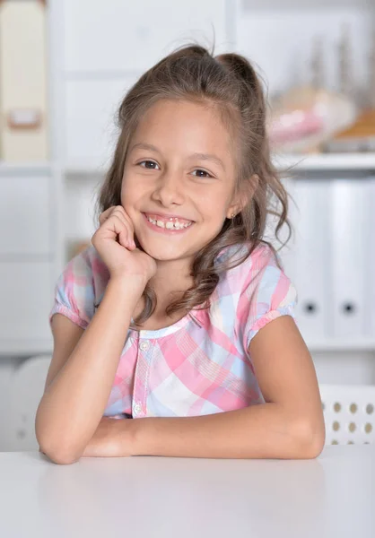 Girl sitting at table — Stock Photo, Image