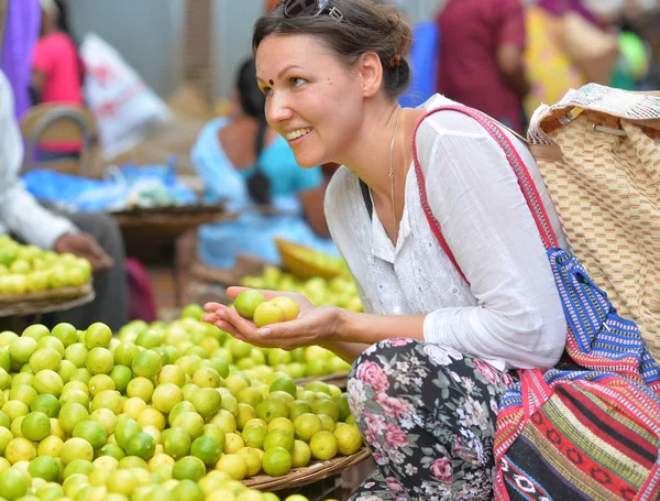 Mujer joven sosteniendo limones — Foto de Stock