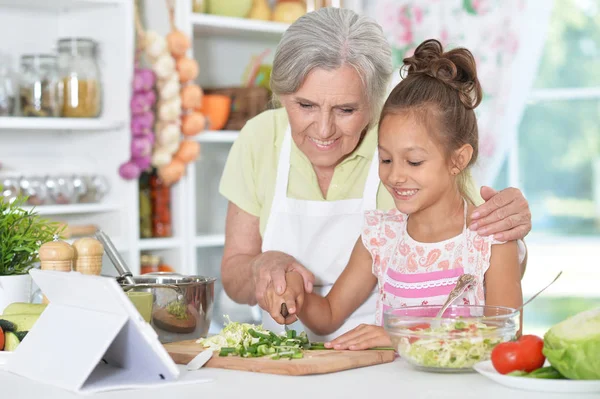 Mormor och barnbarn förbereder middag — Stockfoto