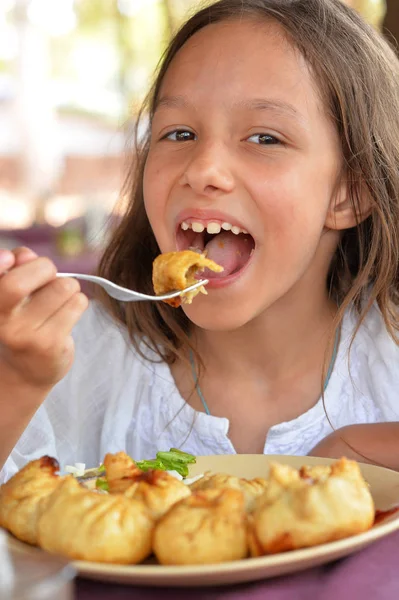 Girl eating meat pockets — Stock Photo, Image