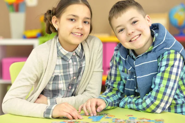 Broer en zus verzamelen puzzel — Stockfoto