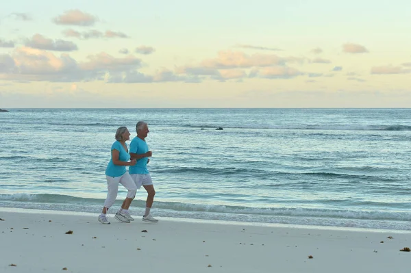 Пара бегущая по пляжу — стоковое фото