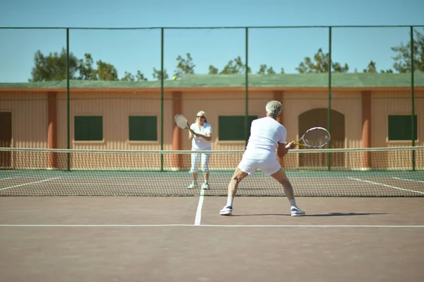 Senior couple on tennis court — Stock Photo, Image