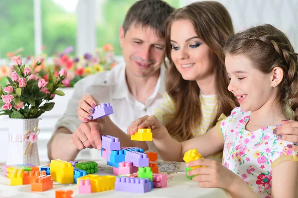 Родители и дочь играют с пластиковыми блоками — стоковое фото
