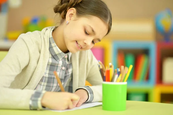 Pequeña colegiala haciendo la tarea — Foto de Stock