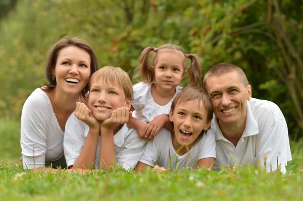 Familie liggend op groen gras — Stockfoto