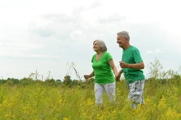 Couple aîné en cours d'exécution sur prairie — Photo