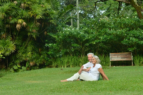 Starší pár, sedět na trávě — Stock fotografie