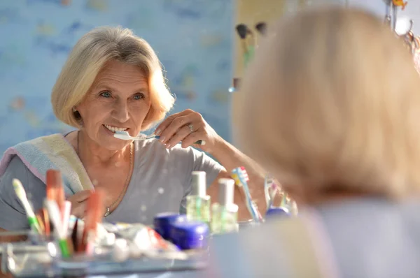 年配の女性が彼女の歯を磨く — ストック写真