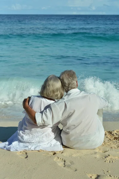 Casal sentado na praia tropical — Fotografia de Stock