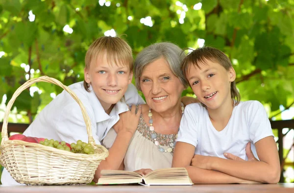 Babcia i wnuków, siedząc przy stole — Zdjęcie stockowe