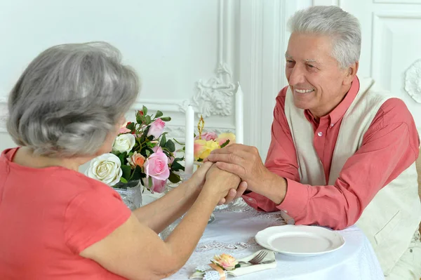 Ler äldre paret sitter vid bord — Stockfoto