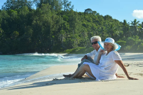 Cocouple sentado en la playa tropical — Foto de Stock