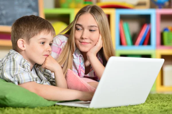 Broer en zus met laptop — Stockfoto